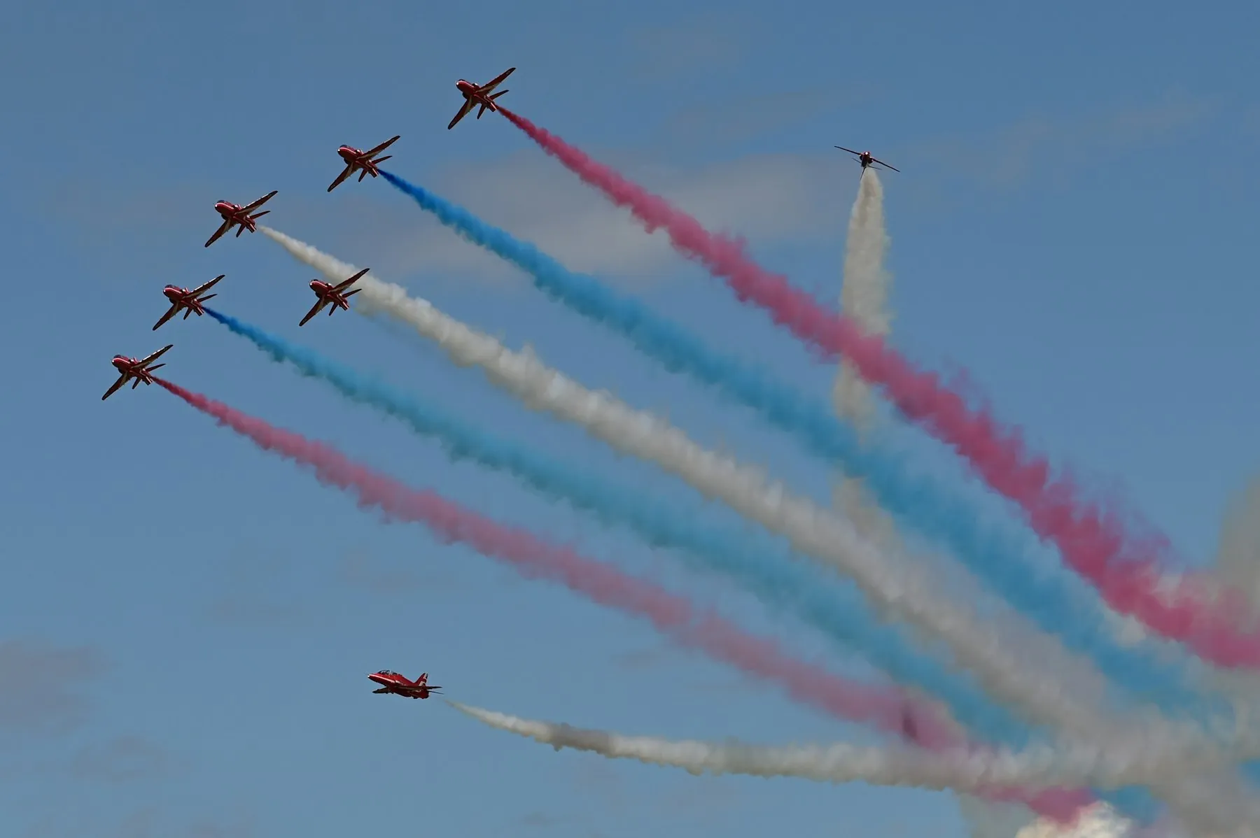 A display team trailing red, white and blue smoke at an airshow